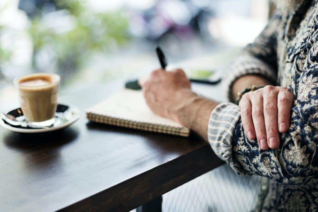 An author making notes in a coffee shop